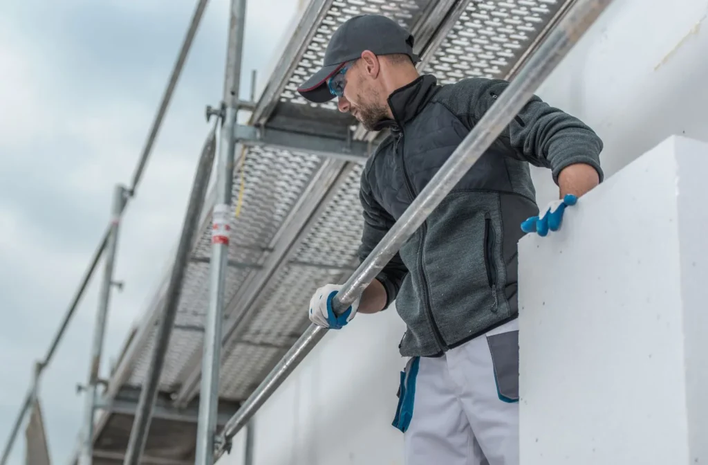 Huntington Beach Scaffolding technician working on elevated platform with safety gear during exterior project